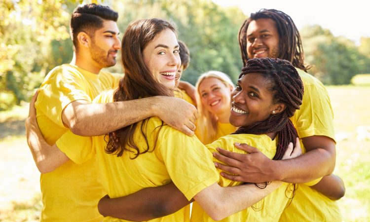 Multikulturelles Start-Up Team umarmt sich im Workshop für Integration und Teambuilding