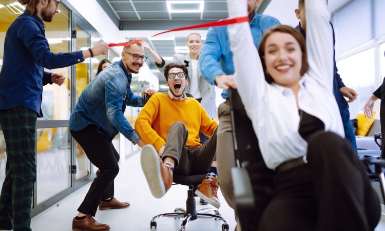 Friendly work team  ride chairs in office room cheerfully excite